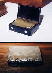 黒いコンポジションのケースと銀のケースに収められたスナッフ･ボックス